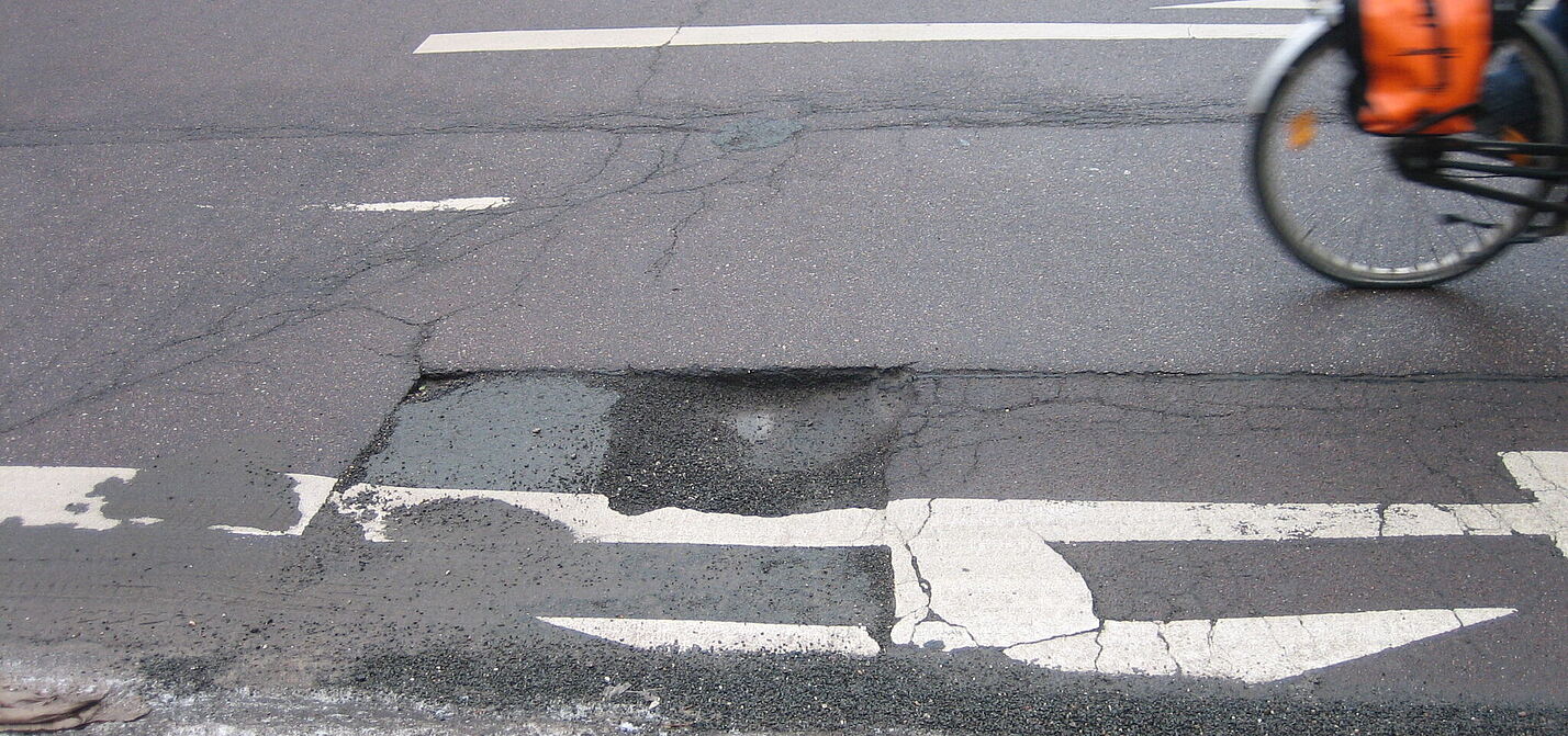 Schlagloch auf der Straße. Schlagloch auf der Straße.