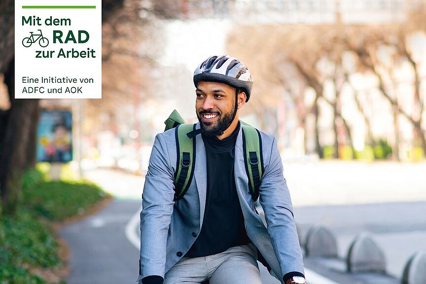 Mit dem Rad zur Arbeit 2022  Mann mit Helm auf Fahrrad und Kampagnenlogos von Mit dem Rad zur Arbeit.