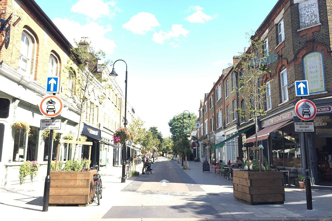 Mini-Hollands in London: In dieser Geschäftssträße wurde die Durchfahrt für Kfz stark eingeschränkt und der Fußgängerbereich ausgeweitet.rt_eingeschraenkt_Fussgaengerbereich_vor_Geschaeften_ausgeweitet Mini-Hollands in London: In dieser Geschäftssträße wurde die Durchfahrt für Kfz stark eingeschränkt und der Fußgängerbereich ausgeweitet.