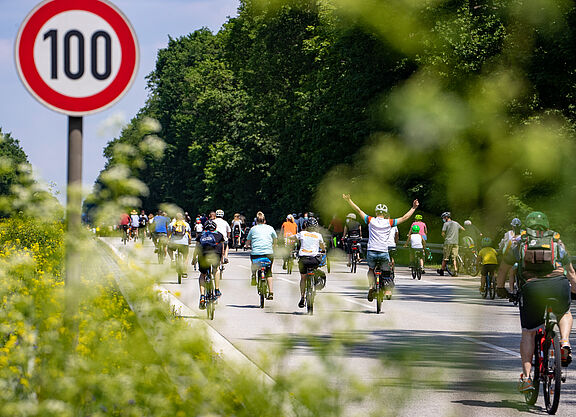 Sternfahrt Berlin Radfahrer bei Sternfahrt neben Schild zu Geschwindigkeitsbegrenzung 100h/km