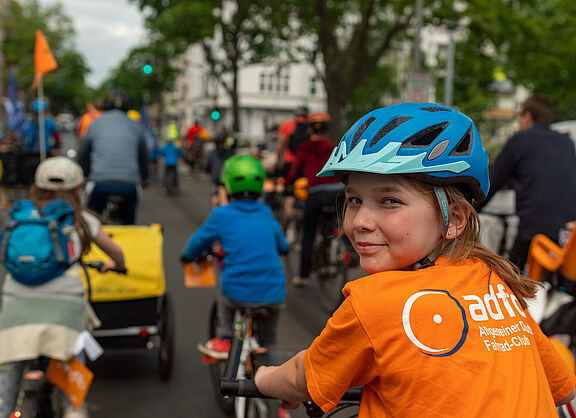 Kind auf Fahrrad schaut in die Kamera