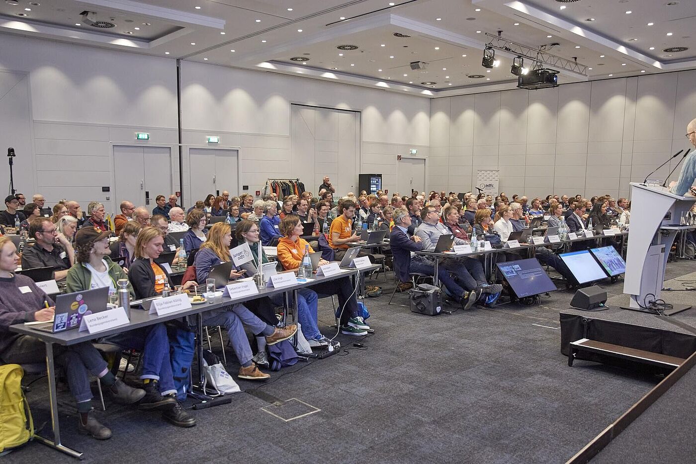 45. ADFC-Bundeshauptversammlung 2025 Voll besetzter Konferenzsaal mit sitzenden Delegierten, die einem Redner am Pult folgen.